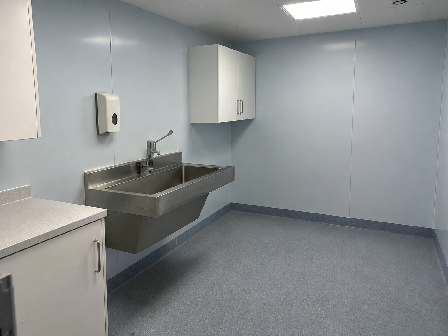 Pale blue hygienic PVC wall cladding and coved safety vinyl flooring in a clinical hand-wash room in Bournemouth, Dorset