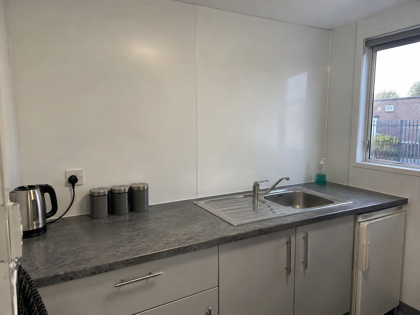 White hygienic PVC wall cladding above the worktop of a staff kitchen in Newport, Isle of Wight